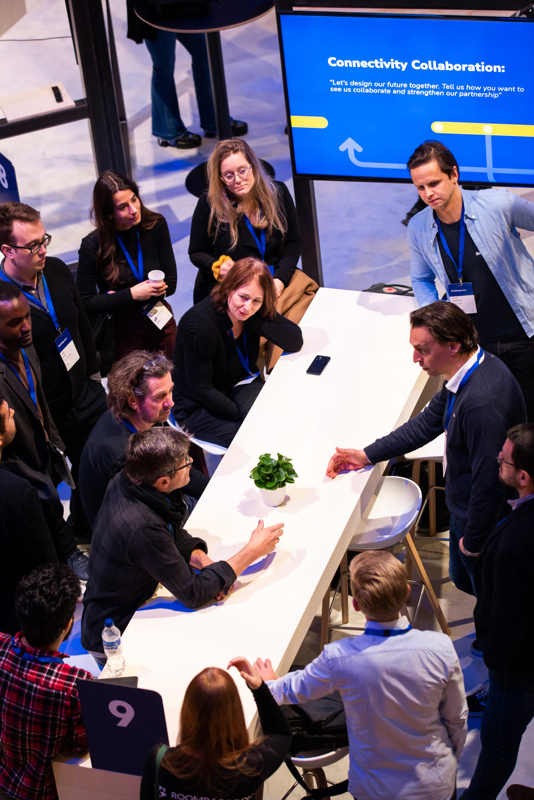 Booking.com team members and connectivity partners collaborating around a table during a workshop.